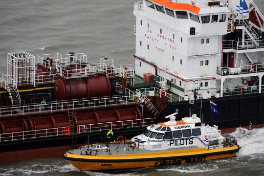 Boot der Lotsen neben einem Schiff