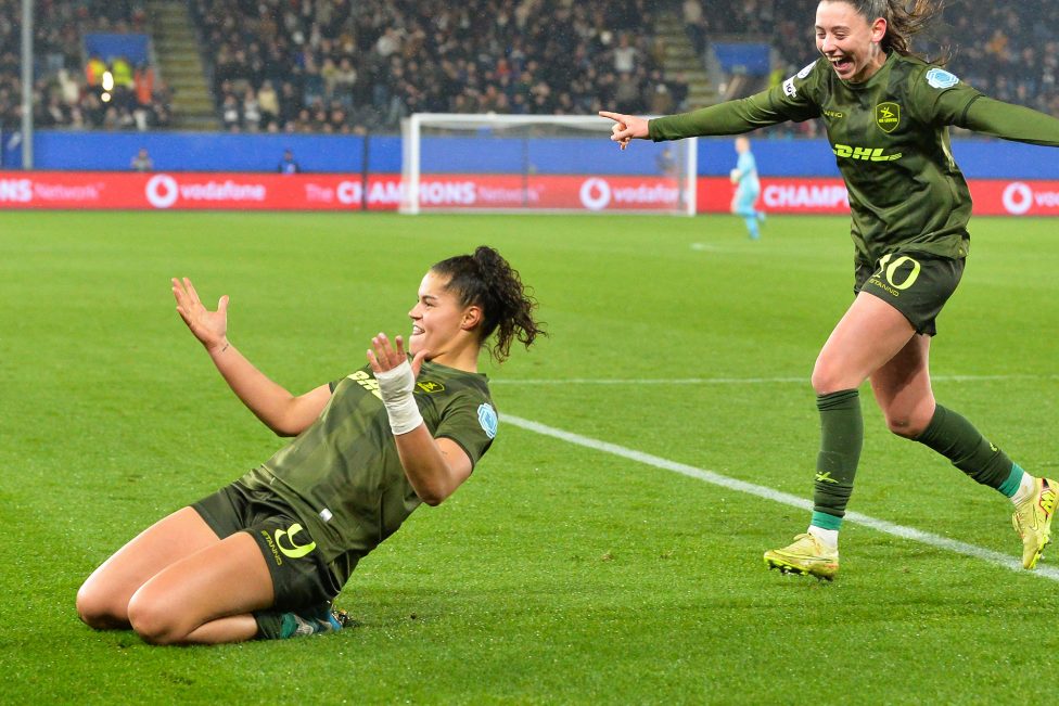 Spielerin kniet auf dem rasen und feiert ihren Treffer