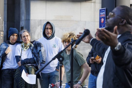Mehrere Personen bei der COP30-Aktion im Europaviertel scheien einem Redner zu