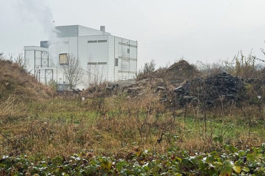 Erd- und Schutthaufen, im Hintergrund die Walhorner Molkerei