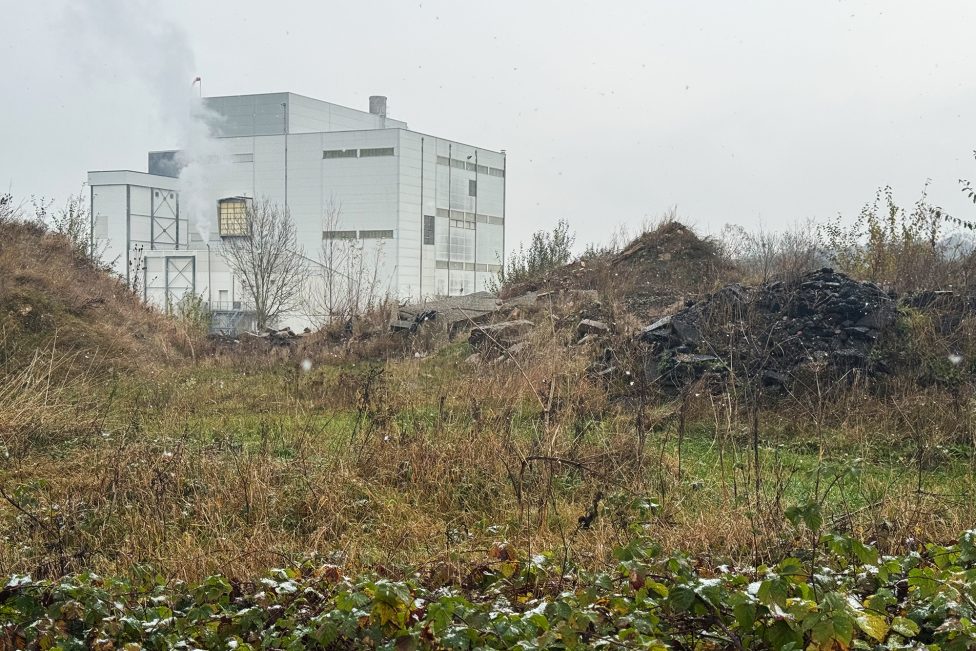 Erd- und Schutthaufen, im Hintergrund die Walhorner Molkerei