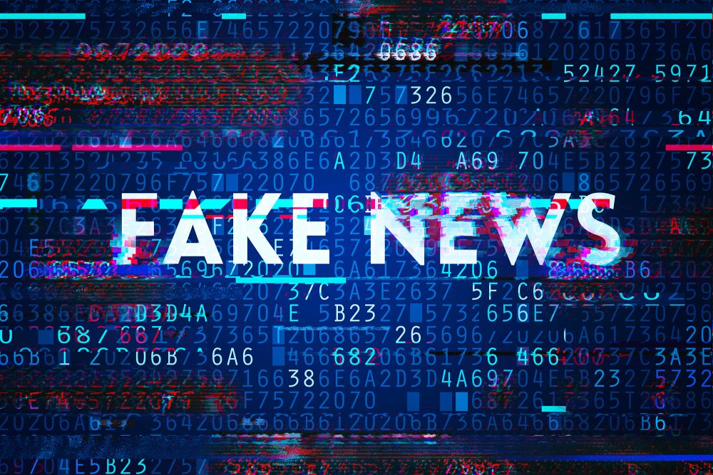 Die Illustration zeigt den Schriftzug "Fake News" vor einem Hintergrund aus Buchstaben und Ziffern, ähnlich den Computer-Zahlenfolgen von Bits und Bytes