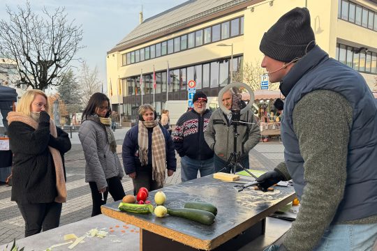 Händler präsentiert seine Produkte vor Besuchern