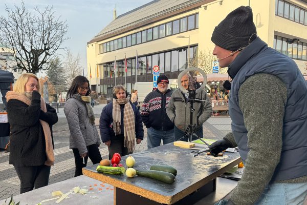 Händler präsentiert seine Produkte vor Besuchern
