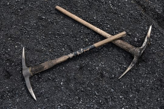 zwei Spitzhacken liegen auf einem Bett aus Kohle