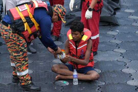 Einer der Flüchtlinge bekommt Wasser von den Rettungskräften