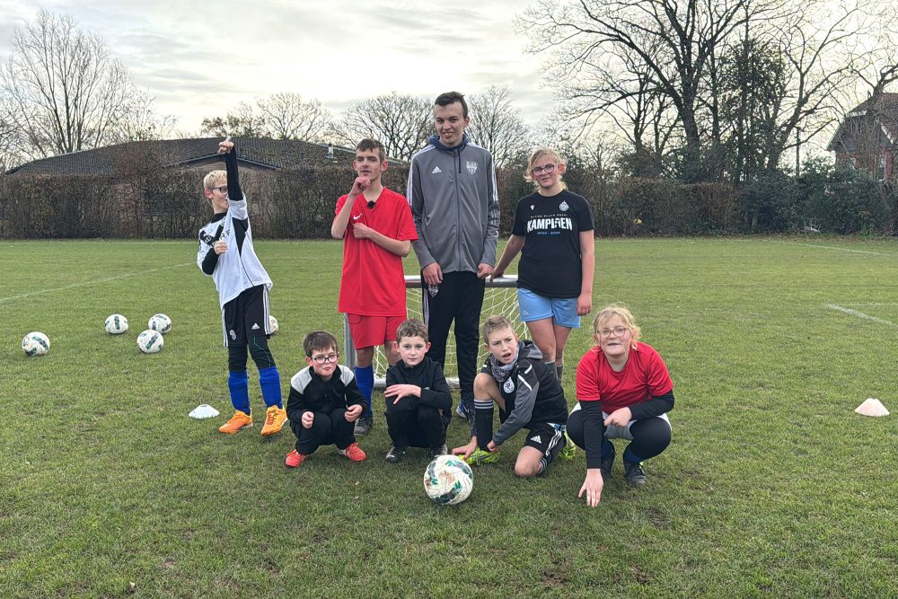 Die acht Kinder von Pandas United stehen vor einem Mini-Fußballtor