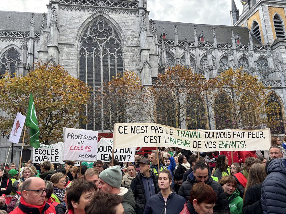 Protestierende Lehrer in Lüttich halten Transparente hoch