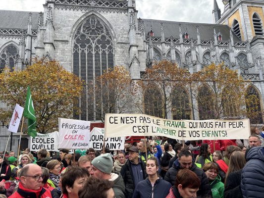 Protestierende Lehrer in Lüttich halten Transparente hoch