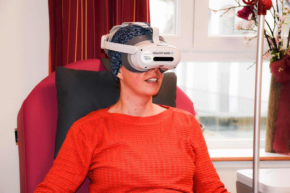 Patientin sitzt mit VR-Brille im Sessel