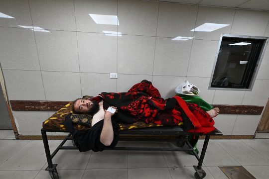 ein verwundeter Mann auf einem Krankenhausbett in einem Flur