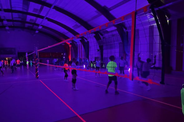 Volleyballer spielen in einer fast dunklen Halle