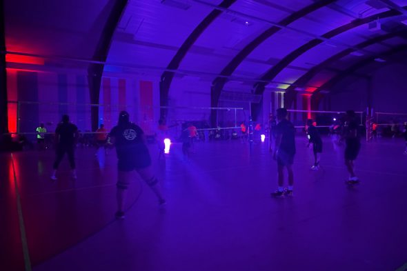 Volleyballer spielen in einer fast dunklen Halle