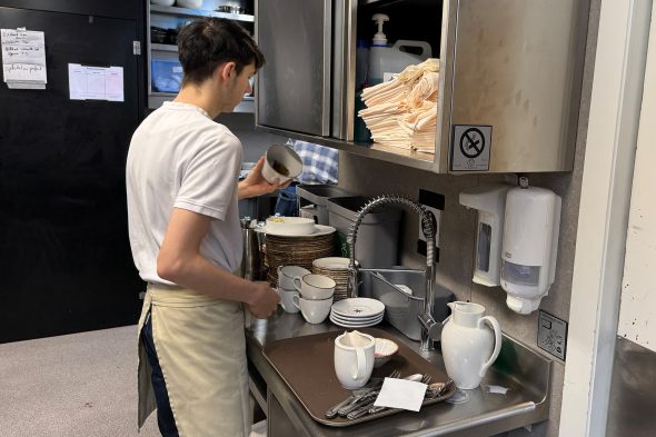 Mitarbeiter spült in der Küche des Bütgenbacher Hofs