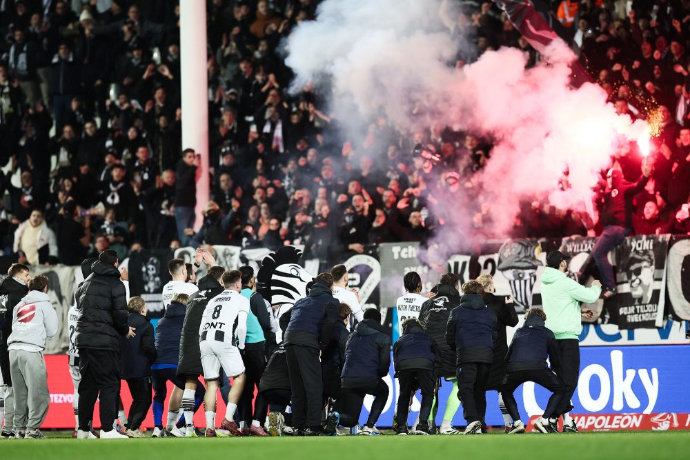 Die Mannschaft von Charleroi steht vor der Fankurve und feiert, im Fan-Block sieht man ein Pyro-Feuer