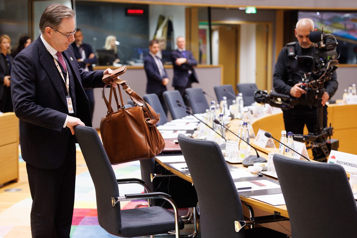 Bart De Wever beim EU-Gipfel, er stellt seine Tasche auf einen Stuhl in einem Tagungsraum