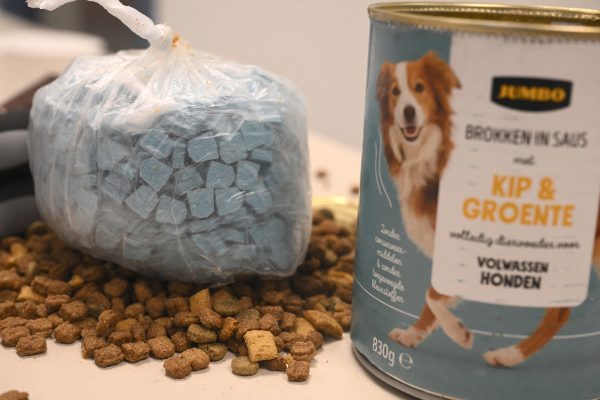 eine geöffnete Dose Hundefutter, daneben Trockenfutter und ein Beutel mit grauen Pillen