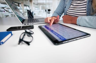 Eine Frau am Schreibtisch mit Laptop und Tablet