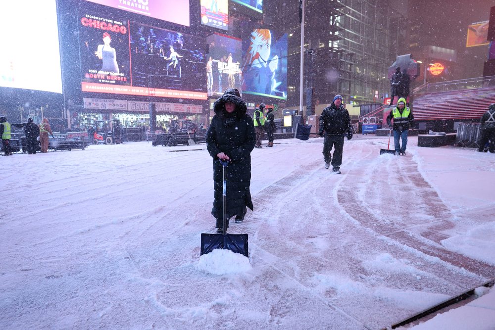 Menschen schaufeln Schnee auf dem New Yorker Times Square