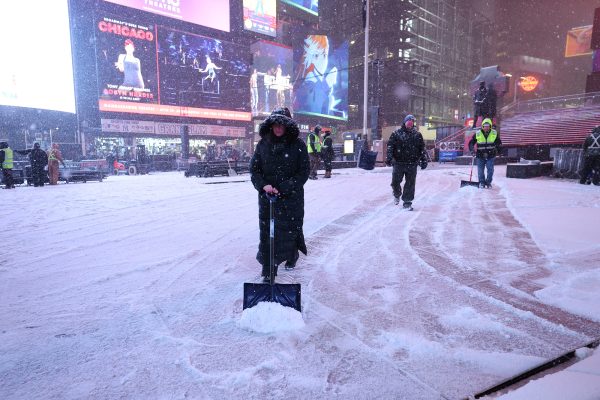Menschen schaufeln Schnee auf dem New Yorker Times Square