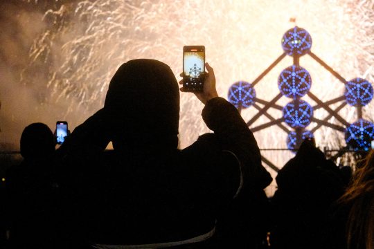 Mann fotografiert das Feuerwerk Silvester 2024 am Atomium in Brüssel