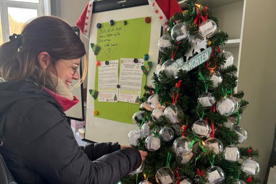Luisa Rauw "pflückt" eine Weihnachtskugel vom Wunschbaum