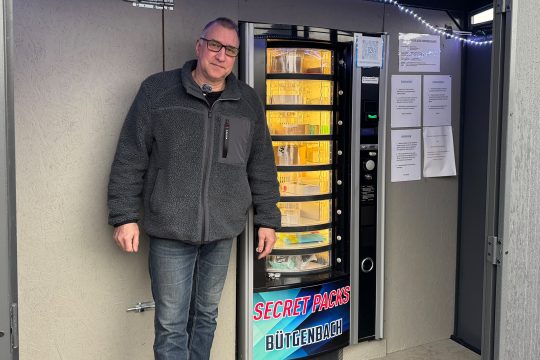Bernd Lauscher vor seinem Secret-Packs-Automaten in Bütgenbach