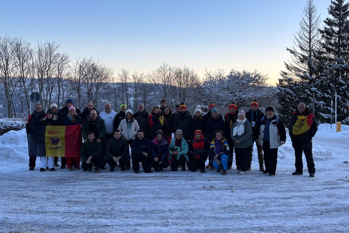 Gruppenbild von rund 30 belgischen Biathlon-Fans auf einer verschneiten Wiese