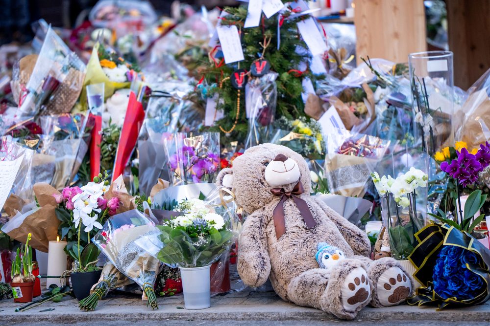 Blumen und Teddybär zum Gedenken der Opfer von Crans-Montana