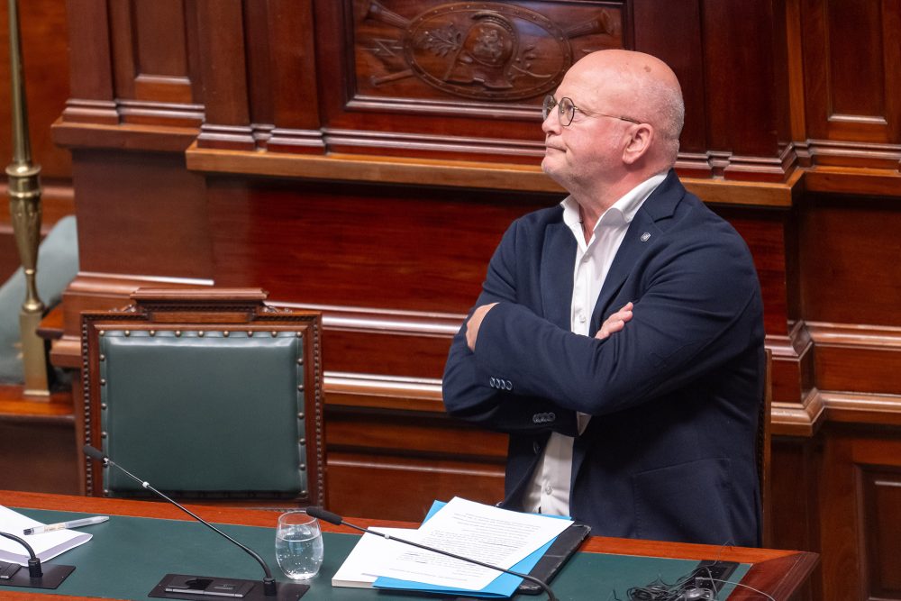 Der föderale Mobilitätsminister Jean-Luc Crucke steht mit verschränkten Armen in der Kammer
