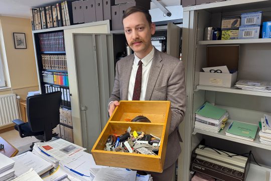 Théo Bolle hält eine Holzkiste mit gefundenen Schlüsseln in den Händen