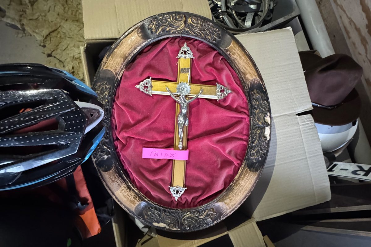 Ein Kreuz mit Jesus liegt auf einem Karton