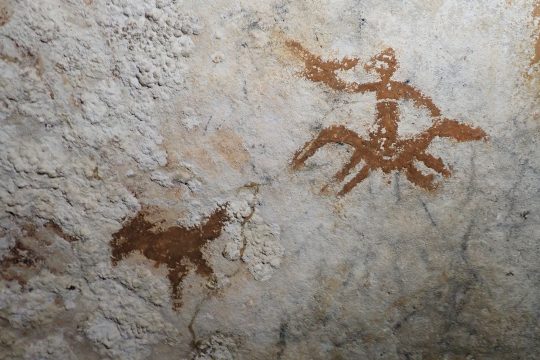 rot-braune prähistorische Höhlenmalereien auf der Felswand