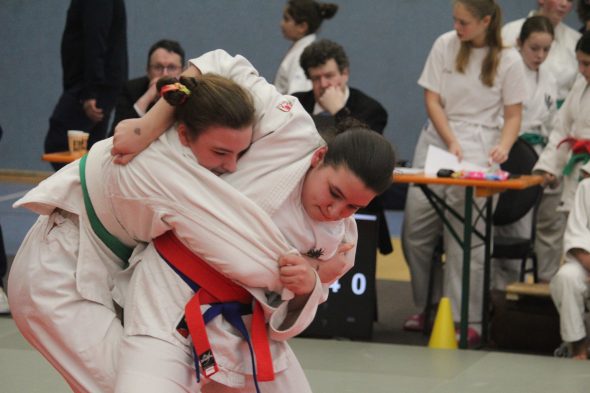 Zwei jugendliche Judokämpferinnen stehen sich auf der Matte gegenüber