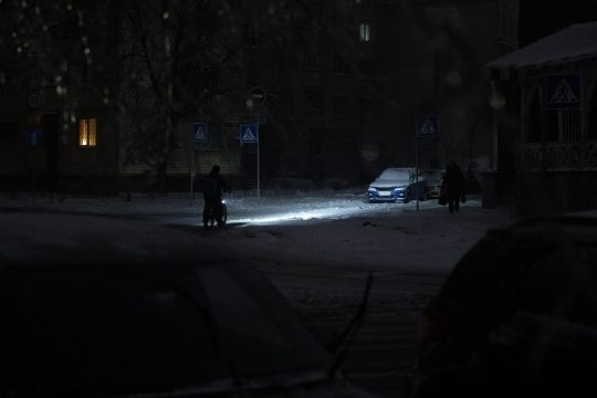 ein Fahrradfahrer auf einer unbeleuchteten Straße in Kiew