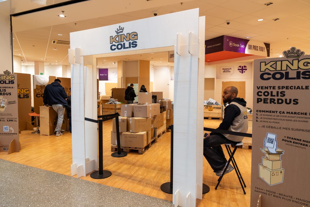 Mitarbeiter sitzt auf Stuhl neben dem Eingangsbereich des Pop-up-Stores