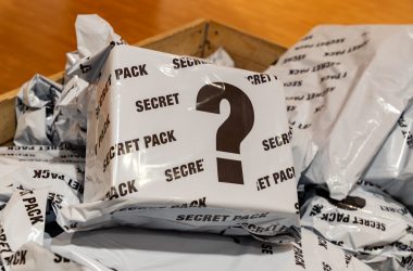 Mystery-Paket in Nahaufnahme, es ist in weißer Folie verschweißt und mit dem Schriftzug "Secret Pack" sowie einem großen Fragezeichen bedruckt