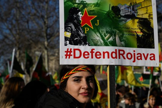 Plakat "Defend Rojava" bei einer Demonstration in Paris zur Unterstützung der Kurden in Syrien