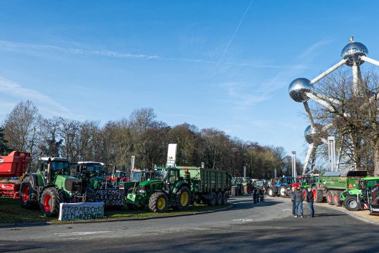 Bauern stehen mit ihren Traktoren vor dem Atomium in Brüssel