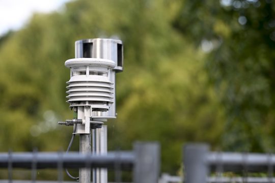 eine metallisch glänzende Messstation ragt aus dem Boden