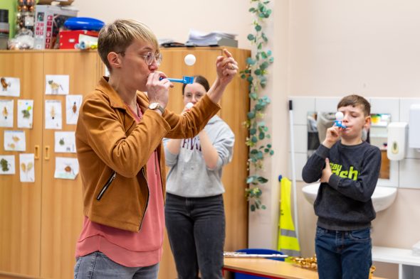 Lehrerin zeigt eine Übung für die Luft