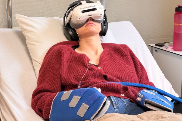Patientin Morgane Loubris mit VR-Brille und Kopfhörern