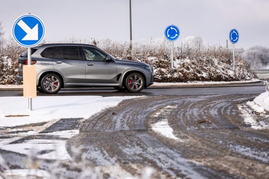 Auto fährt in einen Kreisverkehr bei winterlichen Bedingungen