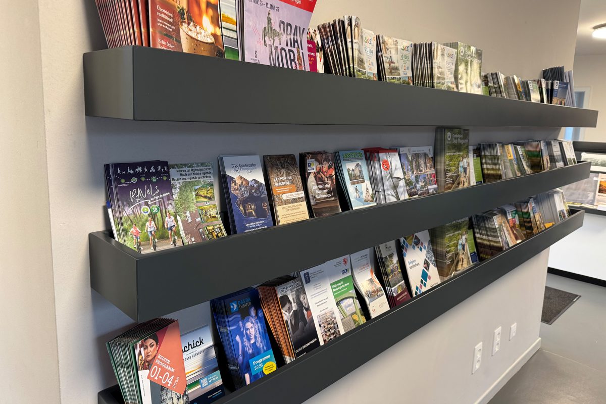 Wandregale mit verschiedenen Broschüren und Faltblättern