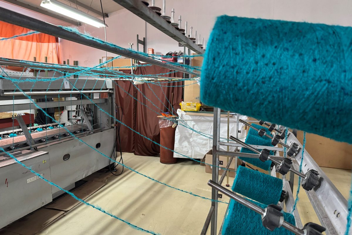 Eine große Spule hängt an der Knäuelwickelmaschine