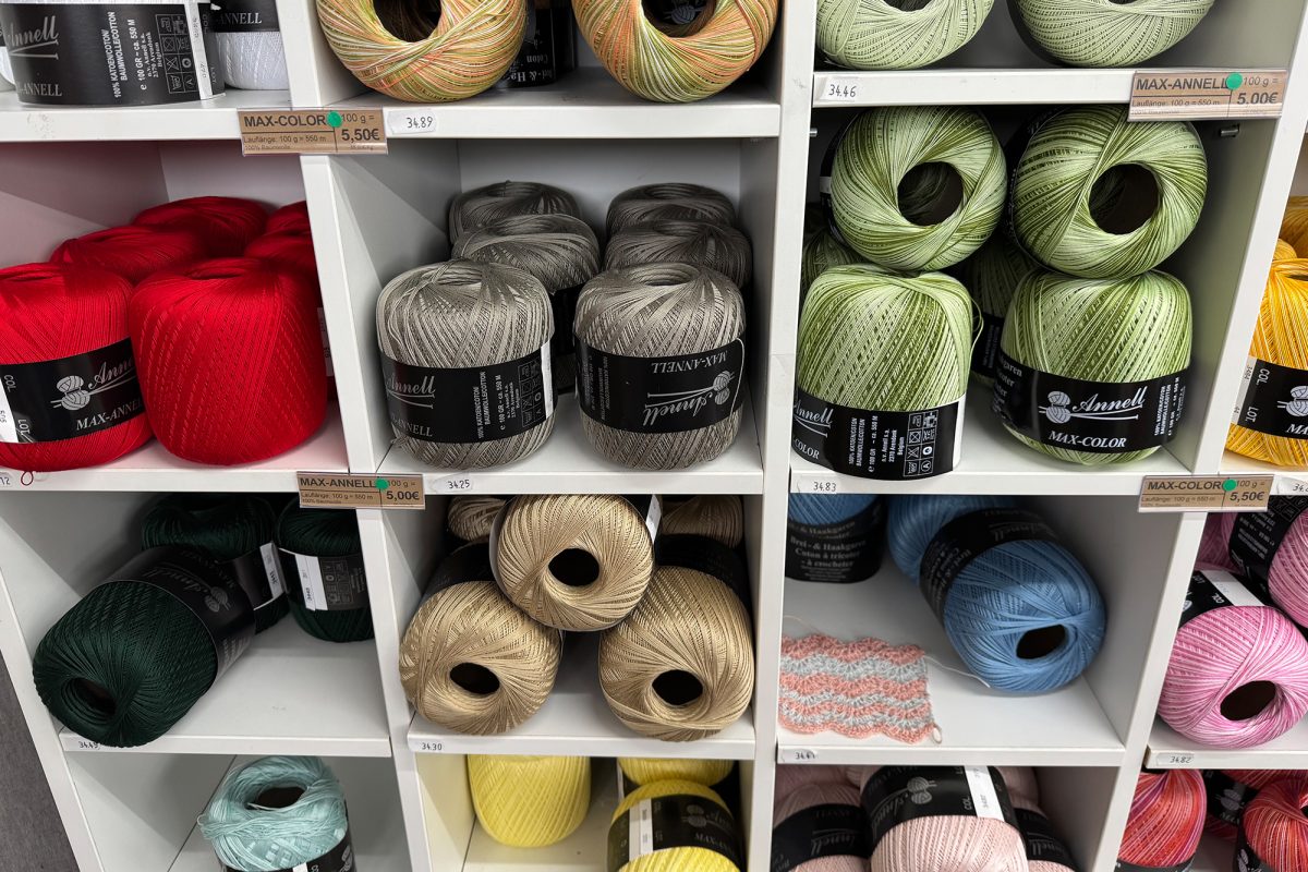 Wollknäuel in diversen Farben liegen für die Kunden im Laden aus