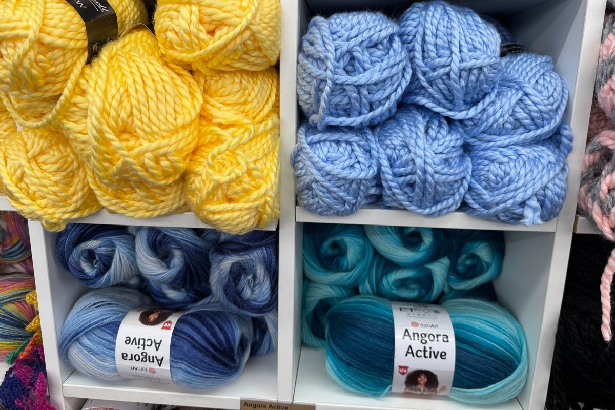 Wollknäuel in diversen Farben liegen für die Kunden im Laden aus