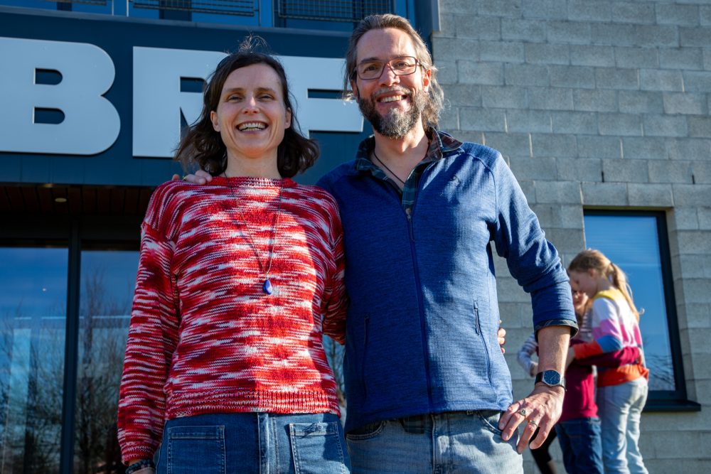 Anna und Patrick Hemminger posieren vor dem BRF-Funkhaus für ein Foto, im Hintergrund sind ihre Kinder