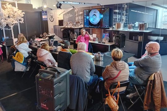 Menschen sitzen auf Stühlen und sind bei einer Produktpräsentation dabei