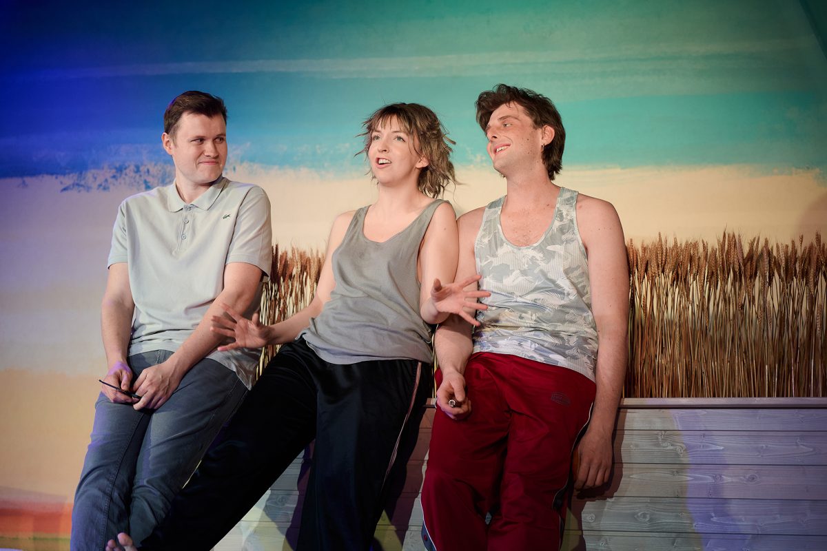 Szene aus dem Theaterstück "Tschick" im Das-da-Theater: Die beiden Hauptfiguren sitzen zusammen mit einer Frau auf der Bühne